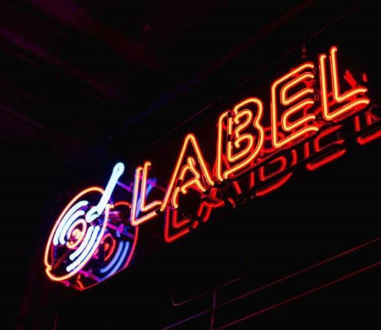 The Impact of Independent Labels on Artist Development Independent label logo with emerging artist performing on stage