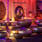 A serene sound bath session with singing bowls and chimes, representing the therapeutic use of vibrations.