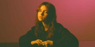 Clairo performing live, reflecting on the emotional depth of her music.