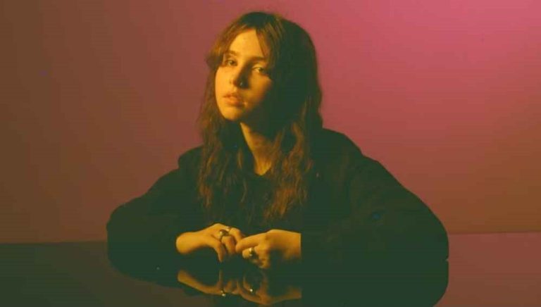 Clairo performing live, reflecting on the emotional depth of her music.