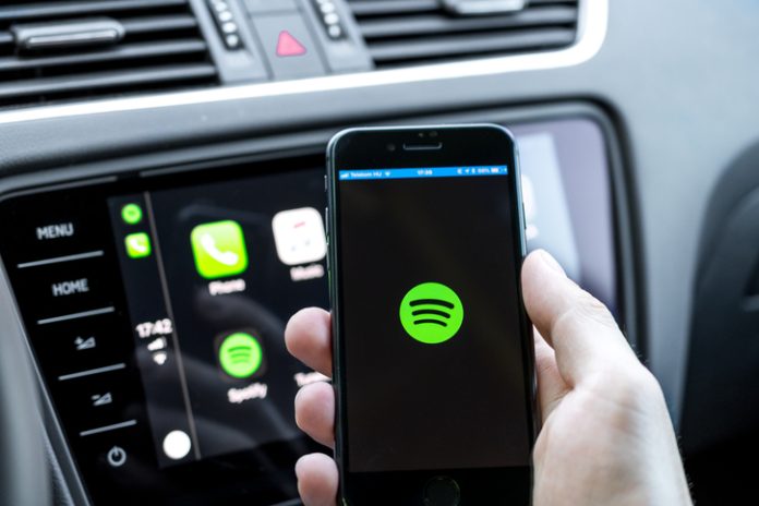 A smartphone displaying the Spotify app on a vibrant background.